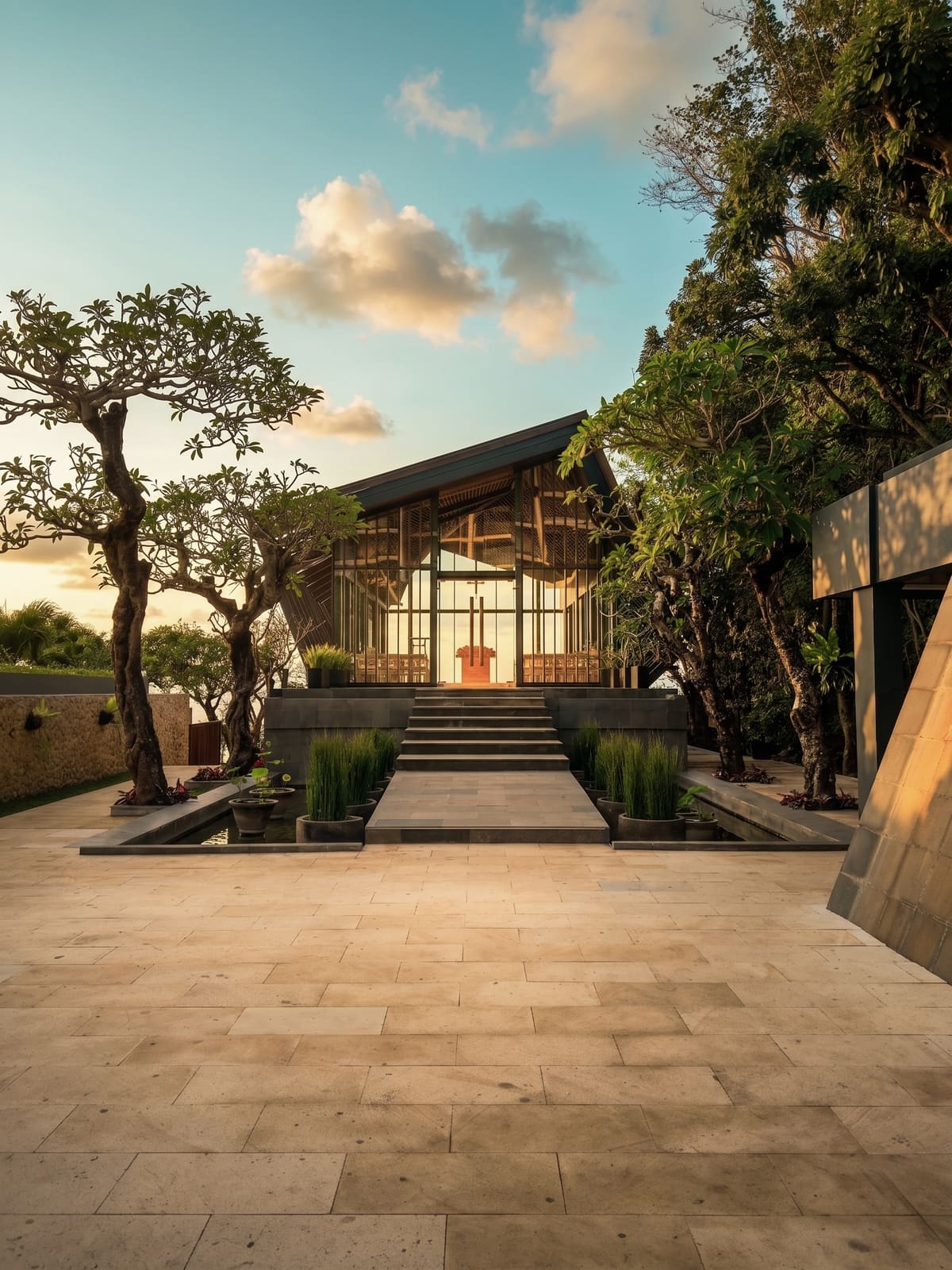 Chapel exterior framed by frangipani trees at sunset